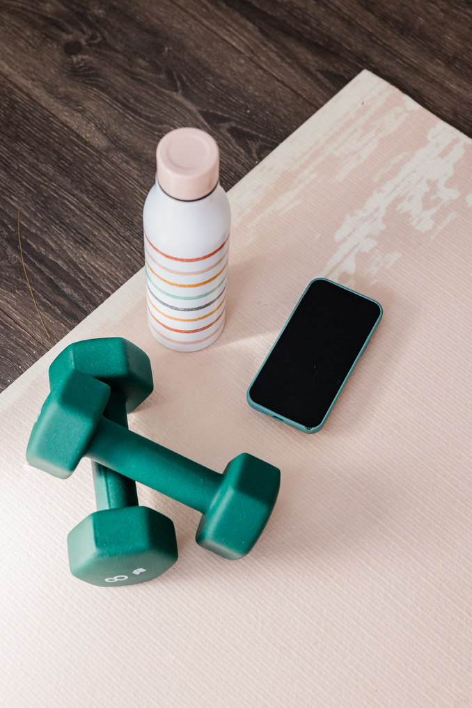 Dumbbells, Water Bottle, and Smartphone on a Table